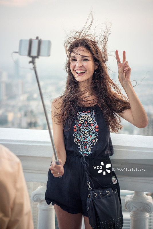 女人在度假时用自拍杆自拍图片素材