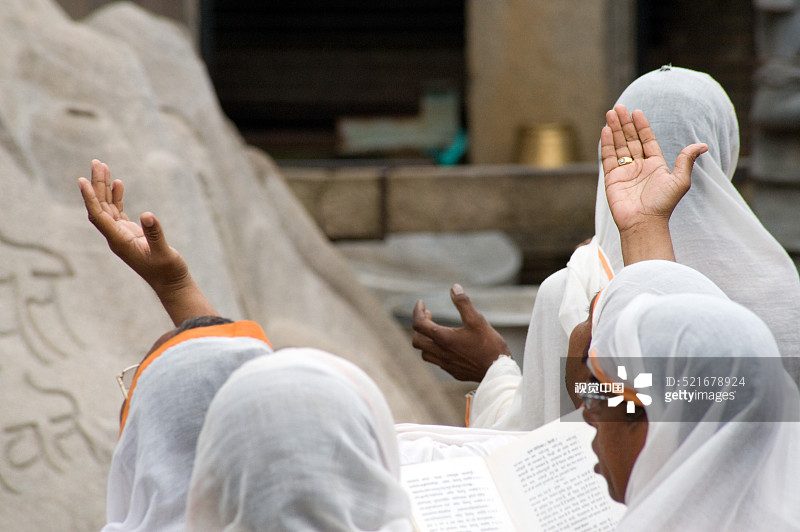 信徒在印度卡纳塔克邦戈马泰什瓦拉耆那教神像前祈祷图片素材