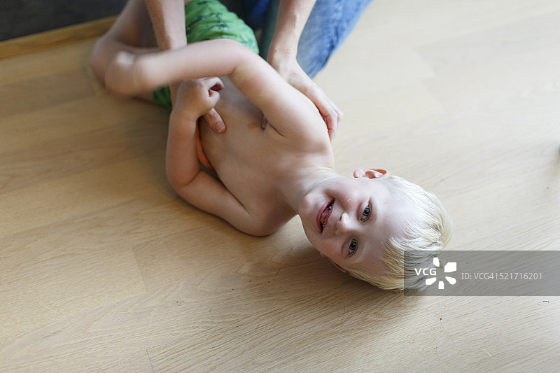 被逗得咯咯笑的小男孩图片素材
