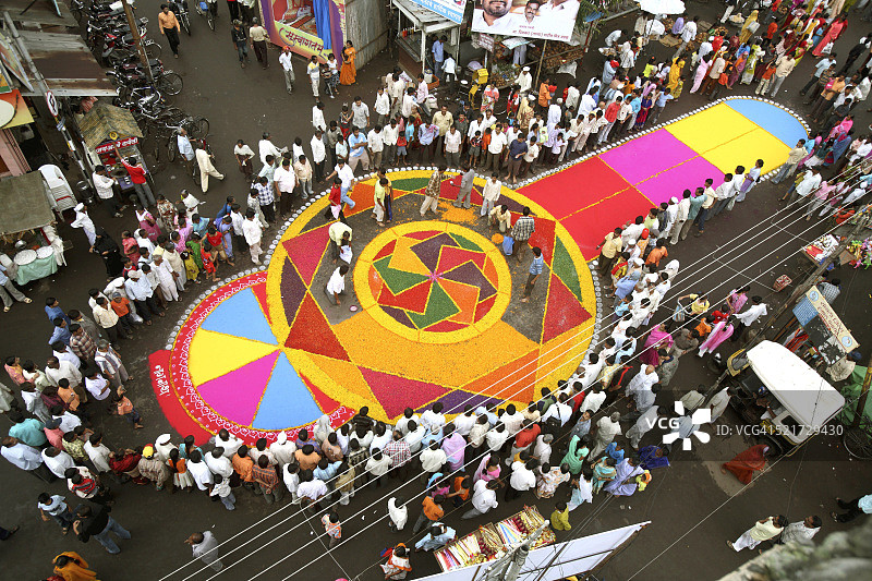 印度马哈拉施特拉邦桑利居民在道路上制作色彩缤纷的蓝果丽花迎接象头神浸礼节图片素材