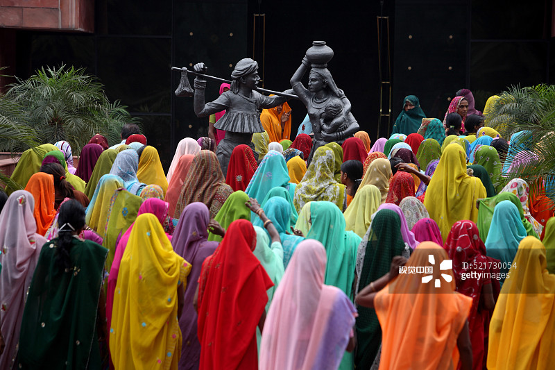 穿着彩色纱丽的女工进入印度古吉拉特邦阿南德的Amul工厂图片素材