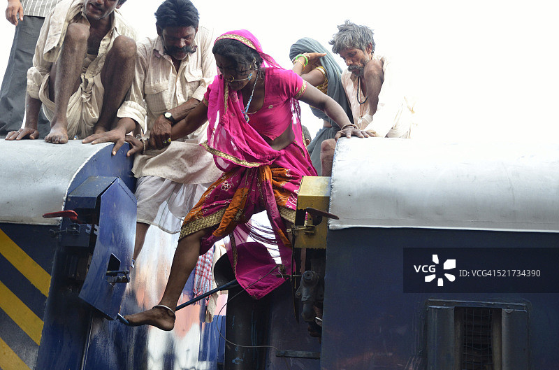 在印度拉贾斯坦邦焦特布尔，女子试图从火车车顶下来图片素材