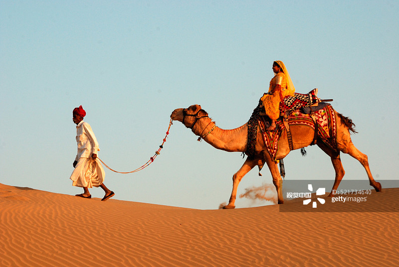 男人在印度拉贾斯坦邦斋沙默尔牵着骆驼图片素材