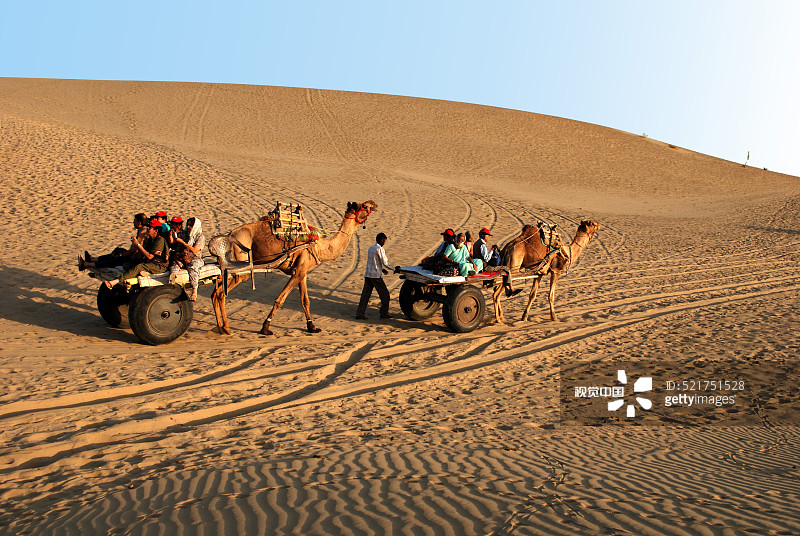 在印度斋沙默尔乘坐骆驼车的游客图片素材