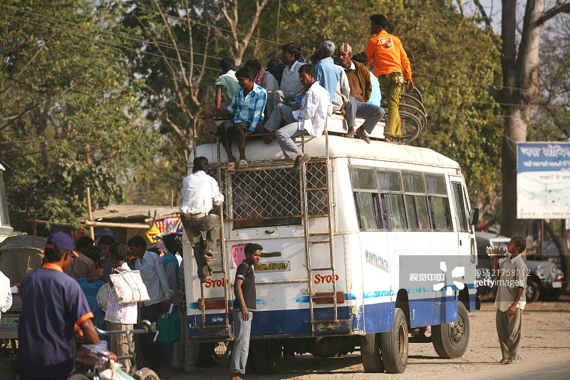 印度贾坎德邦：乘客爬上巴士顶部，使用当地交通工具到达目的地图片素材