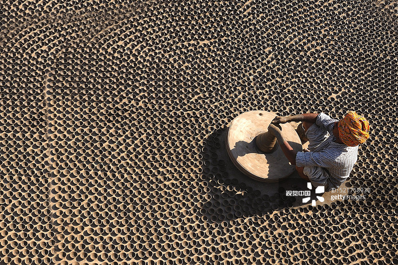 制陶工人在轮子上制作大量泥土，印度拉贾斯坦邦焦特布尔图片素材