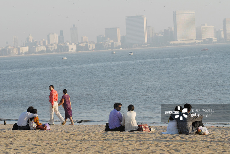 情侣坐在印度孟买吉尔冈乔帕蒂海滩图片素材