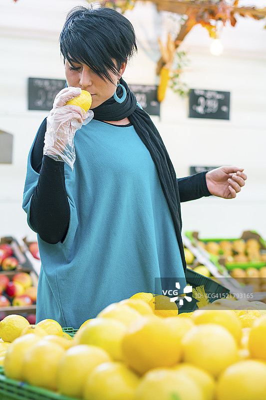 年轻女人挑选和闻柠檬图片素材