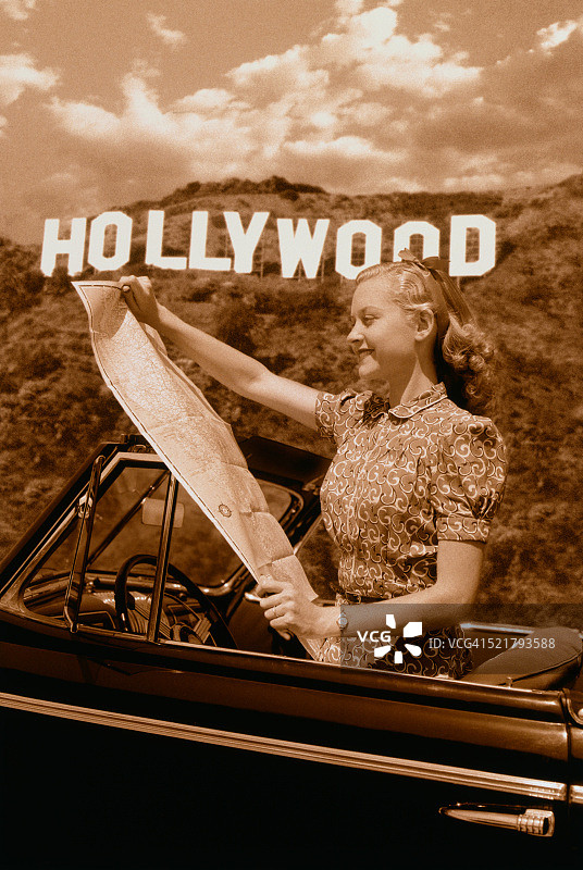 好莱坞标志下敞篷车里的金发女子图片素材
