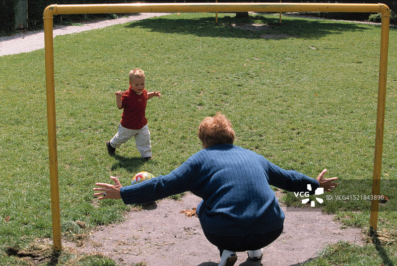 老年奶奶在公园和孙子踢足球图片素材