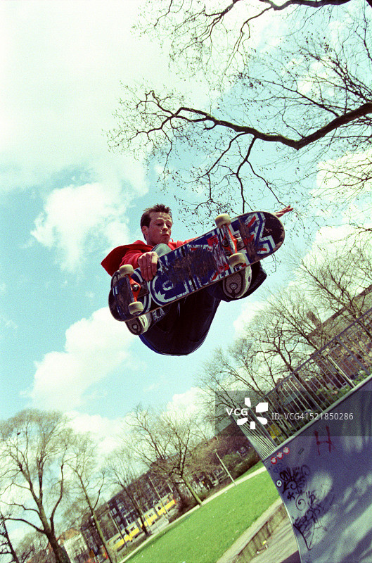 年轻男人玩滑板跳跃图片素材