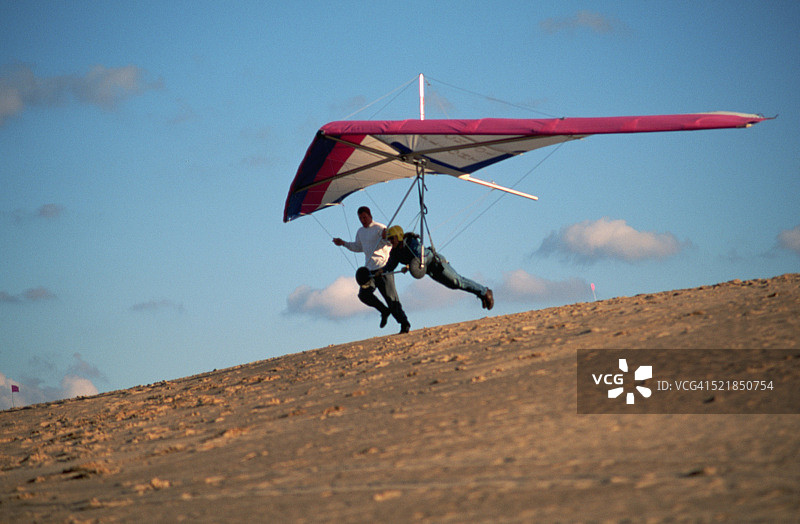 乘坐悬挂式滑翔机起飞的男人图片素材