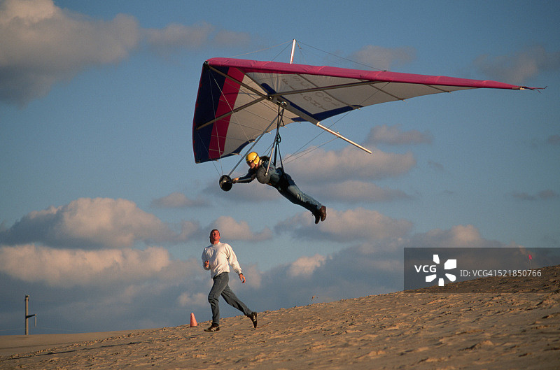 乘坐悬挂式滑翔机起飞的男人图片素材