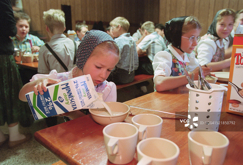 往碗里倒牛奶的女孩图片素材
