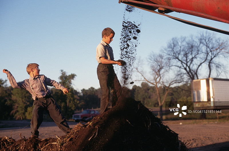 孩子们在农用设备附近玩耍图片素材