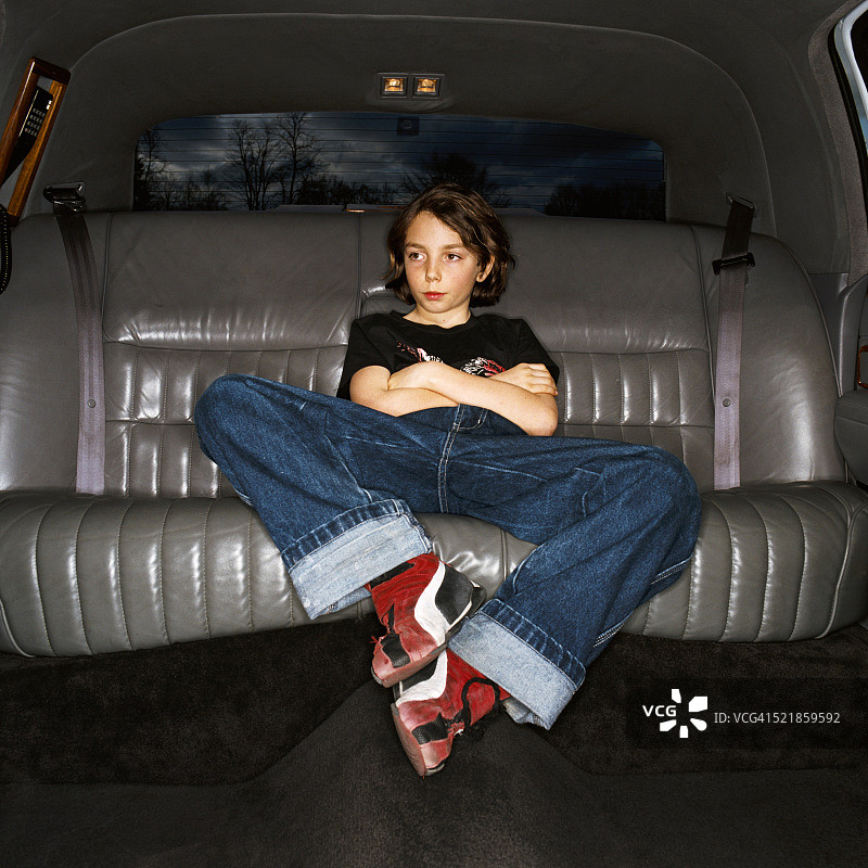 坐在豪华轿车里的小男孩图片素材