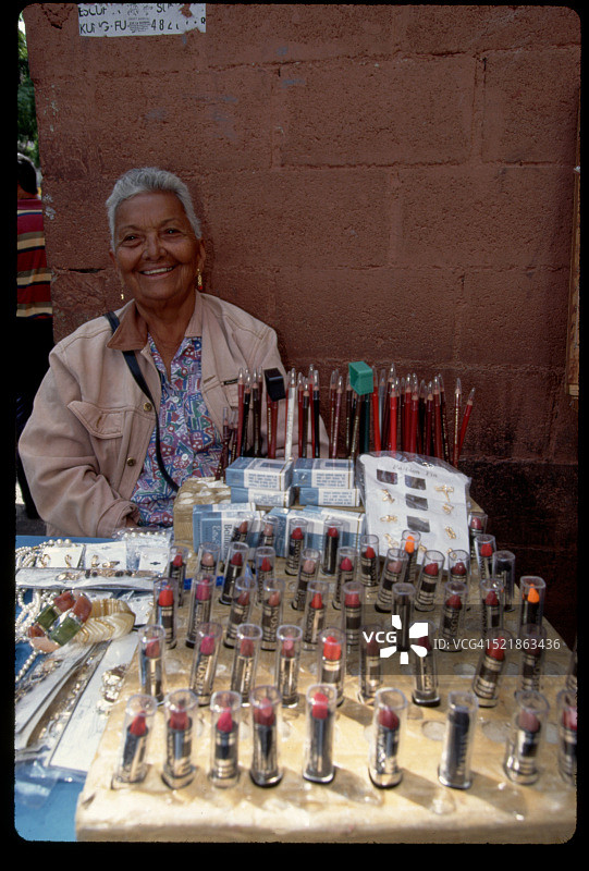 女子在人行道上售卖化妆品图片素材