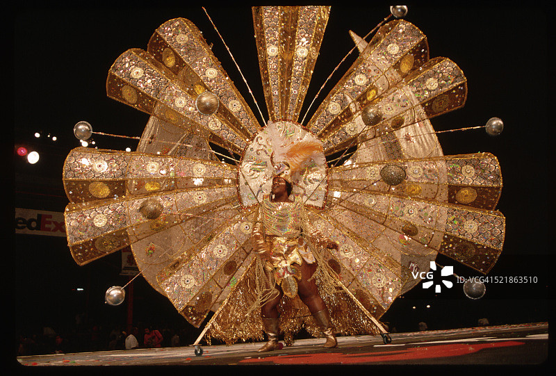 身穿金色华丽服装的女子参加嘉年华比赛图片素材