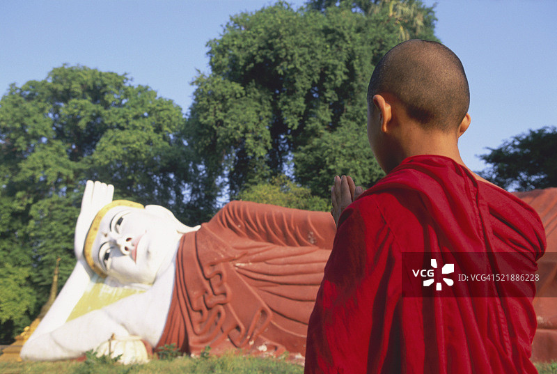 缅甸曼德勒阿玛拉布拉，小沙弥祈祷佛像图片素材