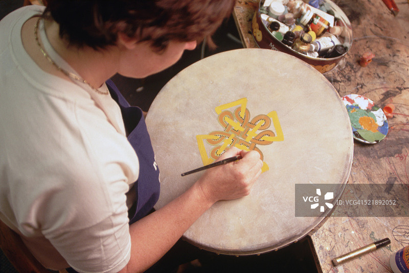 安妮·科恩斯在画一面爱尔兰鼓图片素材