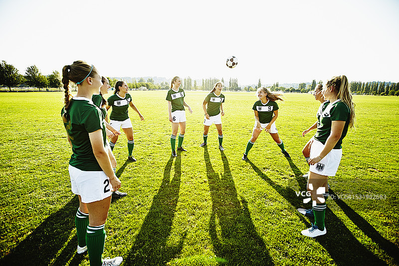 足球队友站成一圈顶球图片素材