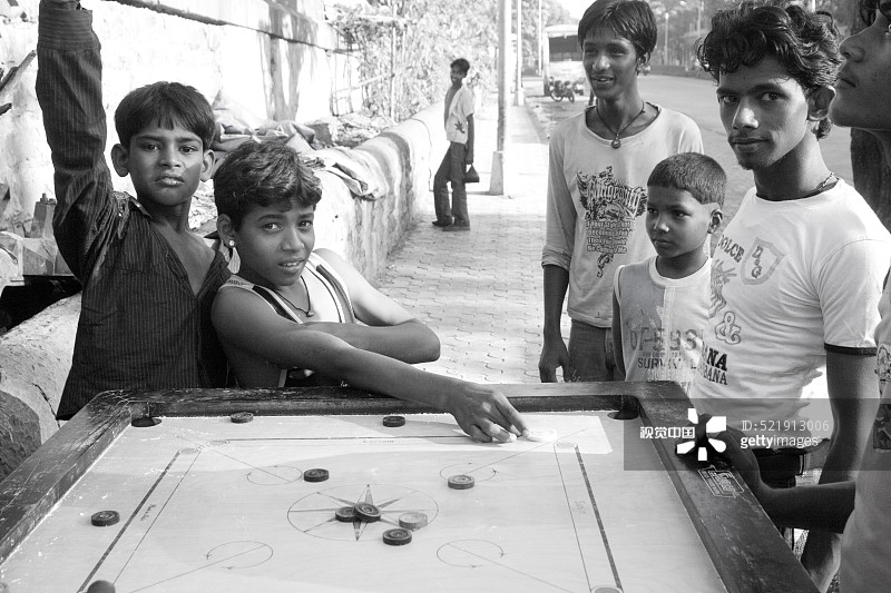 印度马哈拉施特拉邦孟买贫民窟的孩子们玩卡罗姆图片素材