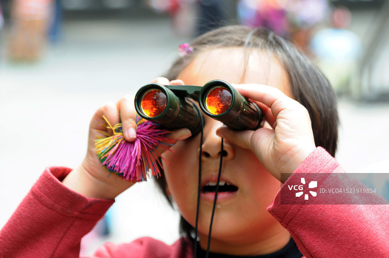 中国北京，在花园里用迷你双筒望远镜凝视的中国女孩图片素材