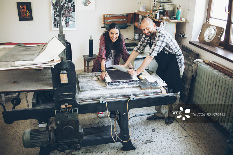 微笑的石版印刷工人在印刷厂手工制作新图案图片素材