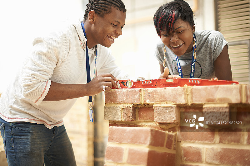 大学生在砌砖车间使用水平仪图片素材