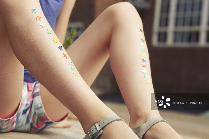 贴满星星贴纸的女孩腿部特写图片素材