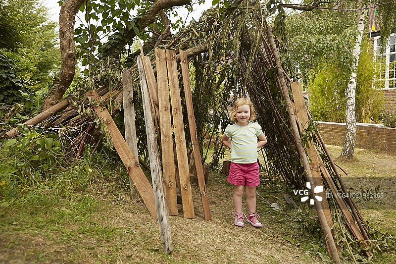 双手叉腰站在花园里的女孩肖像图片素材