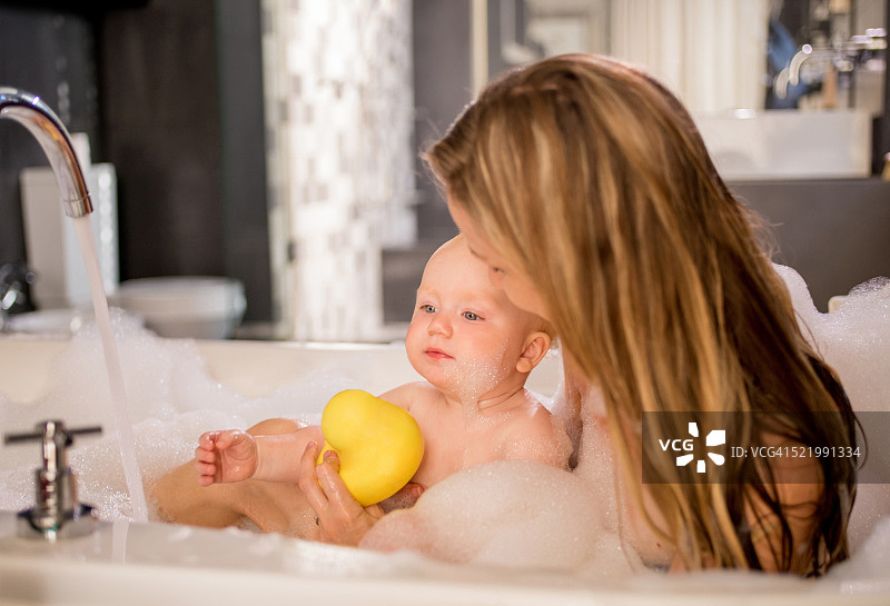 现代妈妈与小女儿一起泡泡浴图片素材