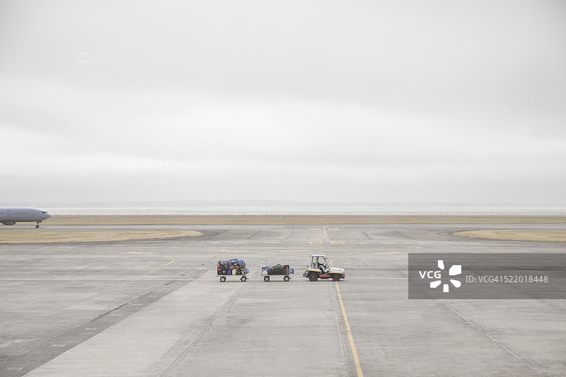 奥克兰机场跑道上的行李车和飞机，新西兰北岛图片素材