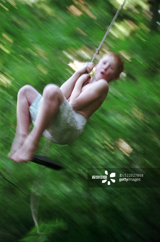 男孩在绳索秋千上荡秋千图片素材