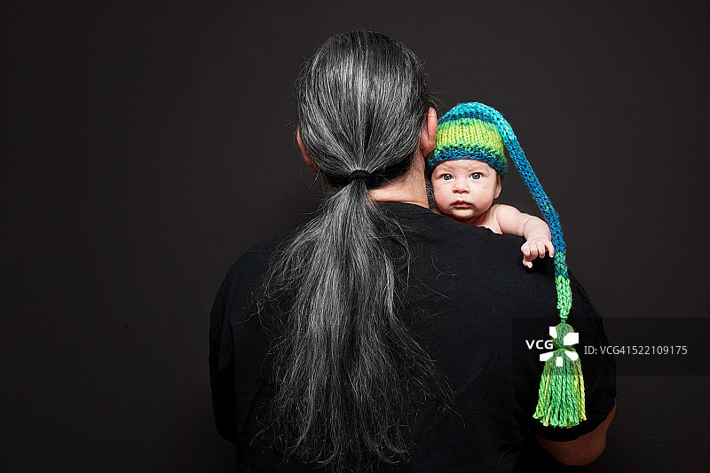 戴着针织帽的宝宝趴在父亲的肩膀上图片素材