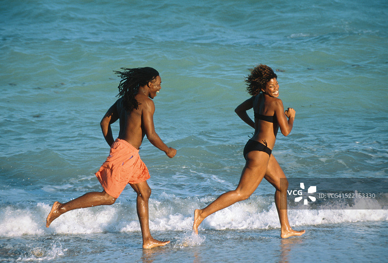 在海滩上奔跑的年轻夫妇图片素材
