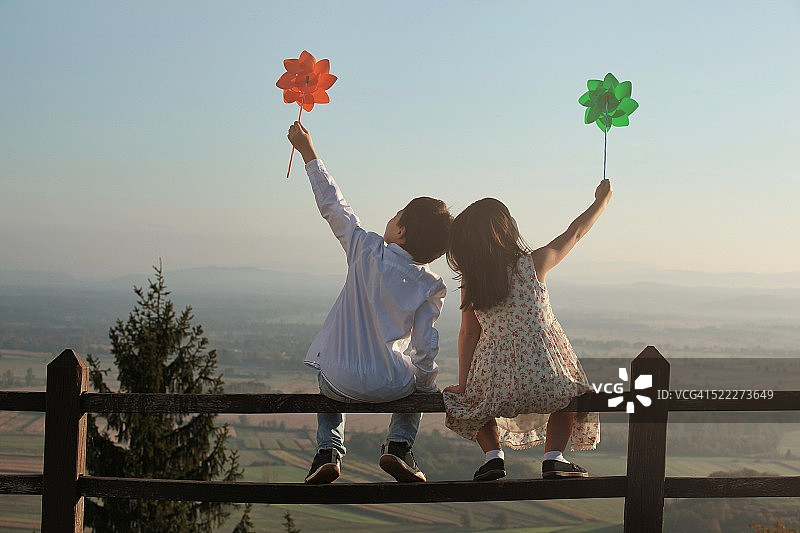 男孩和女孩拿着风车俯瞰沼泽图片素材