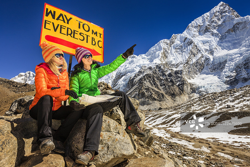 年轻女性在尼泊尔喜马拉雅山脉的路标旁研究地图图片素材