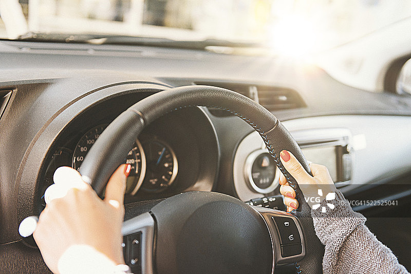 白天，女人手握方向盘开车图片素材