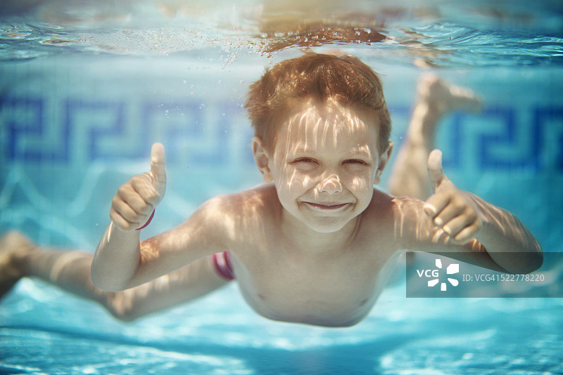 在泳池水下游泳的小男孩肖像图片素材