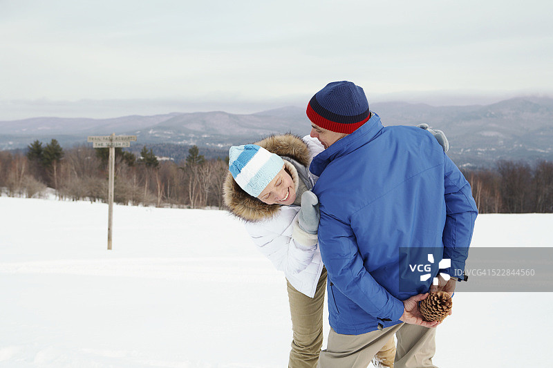 男人藏在身后的松果图片素材