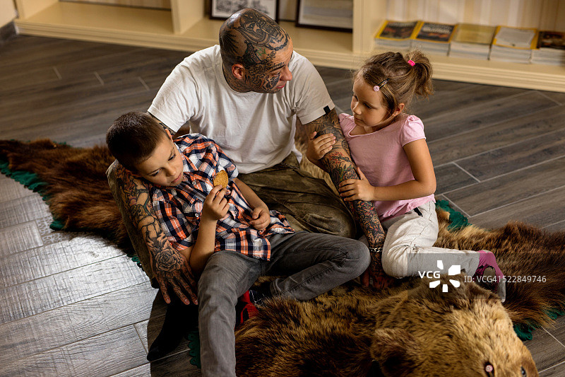父子和孩子们坐在地毯上交流图片素材
