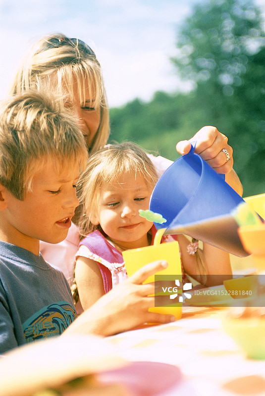 在野餐时为儿子倒果汁的女人图片素材