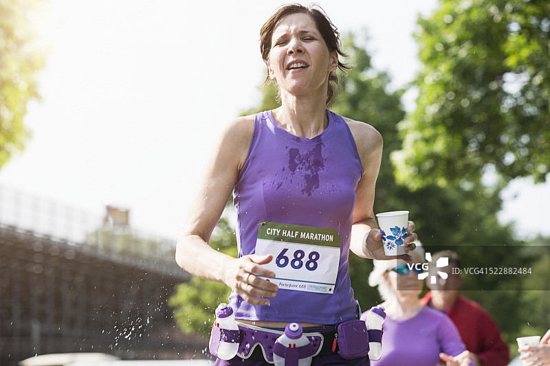 公路赛中拿着水杯的年轻女子图片素材