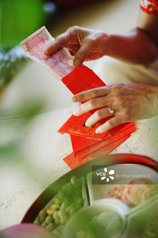 女性将钱塞进春节红包图片素材