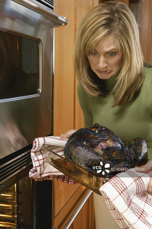 女人拿着烤焦的火鸡图片素材