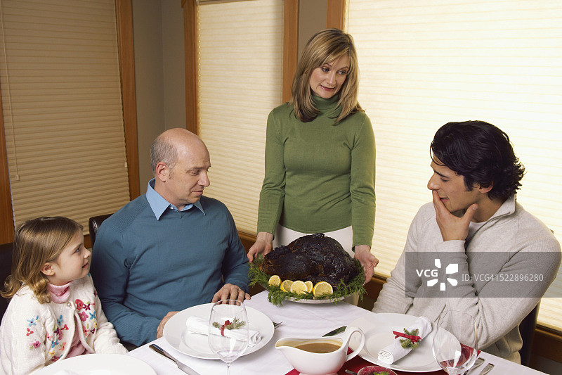 女人为家人端上烧焦的火鸡图片素材