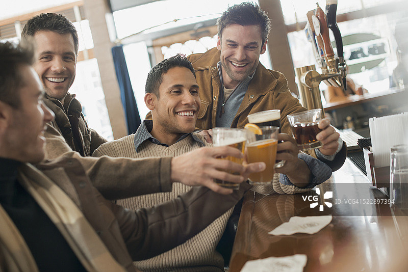 男性朋友在吧台碰杯祝酒图片素材