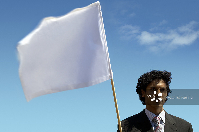男人在蓝天下举着白旗的肖像图片素材