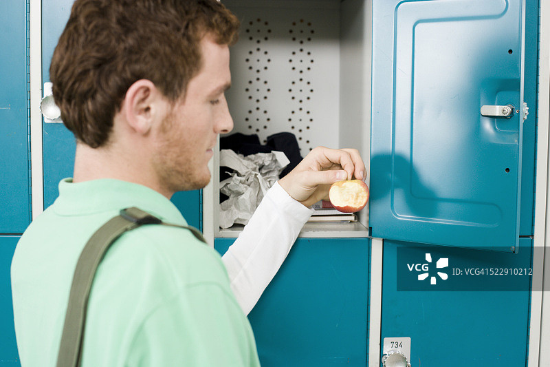 困惑的男人在储物柜里发现苹果图片素材